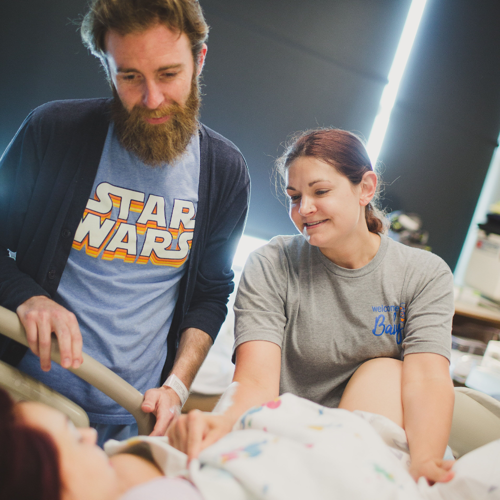 A husband and a birth doula providing assurance to a laboring mother