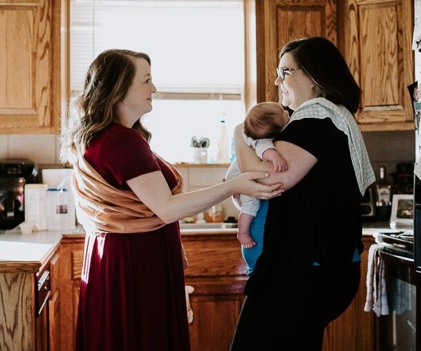 A mother and her child recieving in-home care from a postpartum doula
