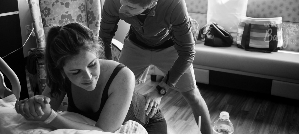 A woman recieving a back massage from her partner during labor
